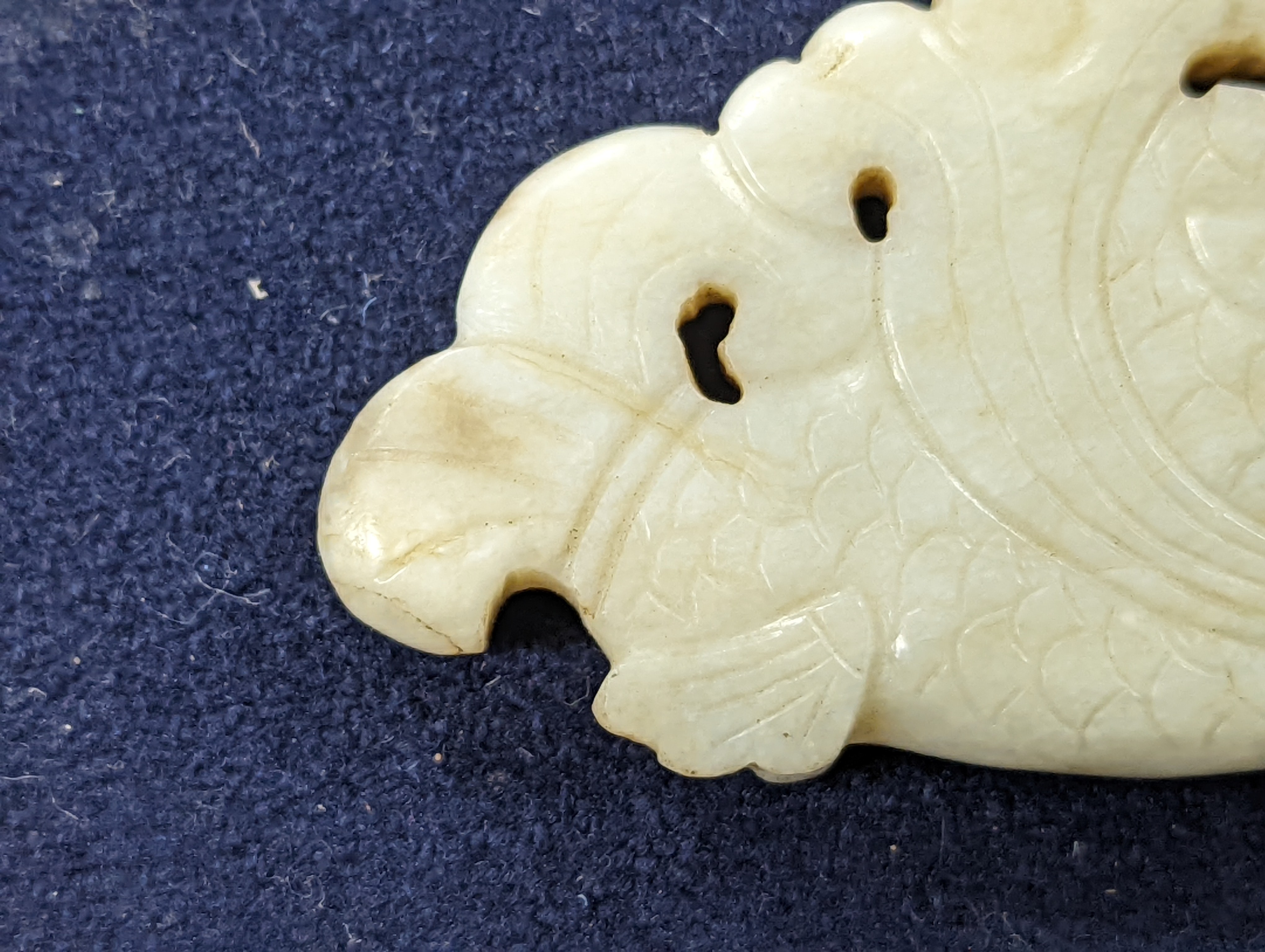 A Chinese white and black jade ‘dragon-fish’ plaque, 19th/20th century, 6cm